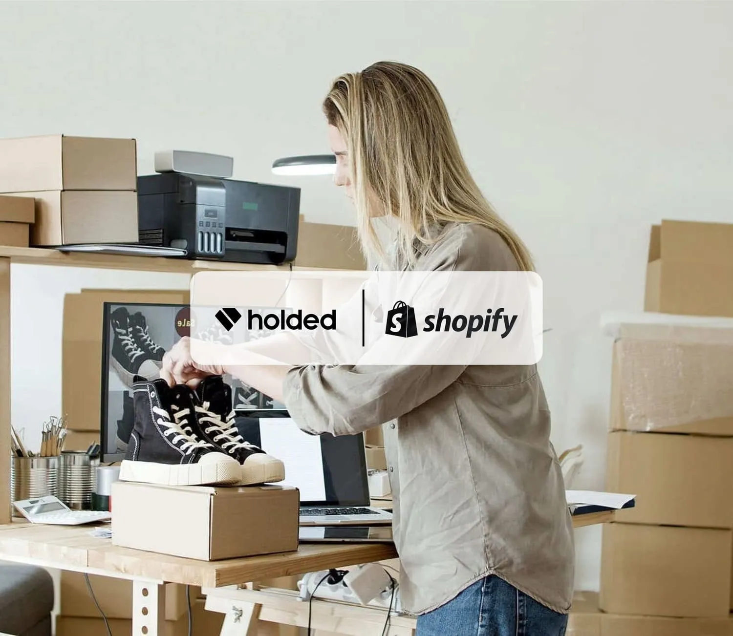 Mujer vendiendo en su tienda con los logos de Holded y Shopify