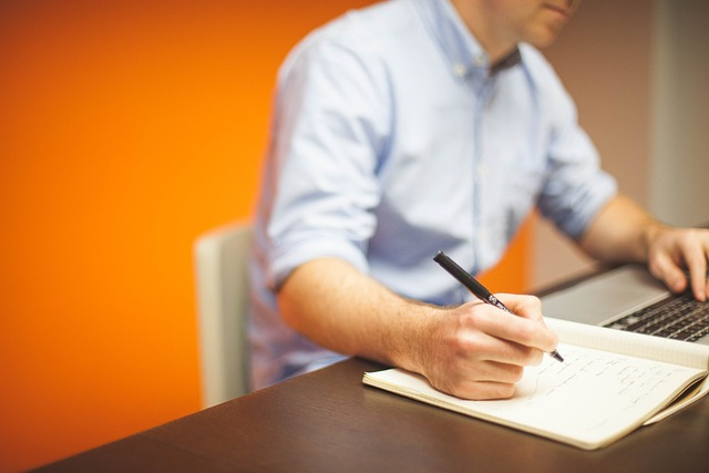 hombre escribiendo en un cuaderno